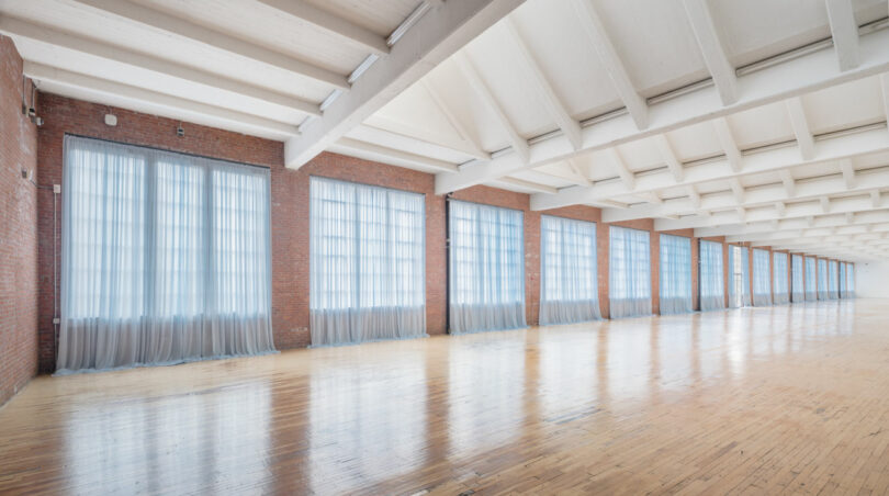 Hallway of large windows with blue translucent curtains