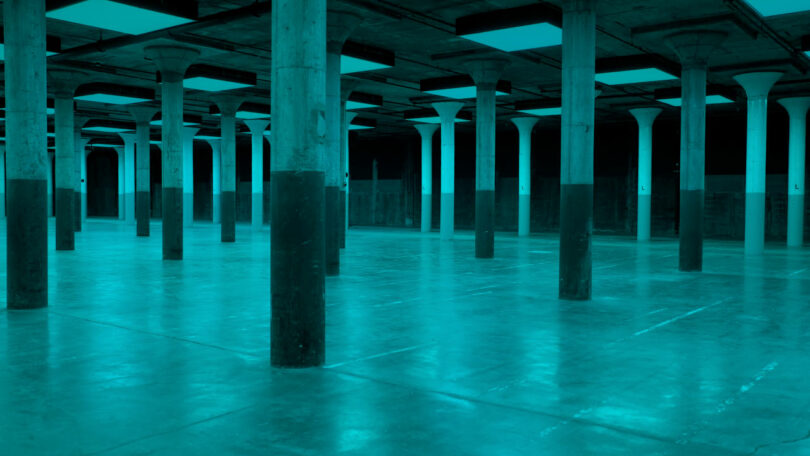 Large room with concrete pillars under aqua light